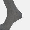 View 4 of product A single Steel Melange Micro Knit Mid-Length Sock by Turnbull & Asser, knee-high and gray, crafted from mercerised Egyptian cotton with a subtle micro knit pattern, is displayed upright on a plain white background.