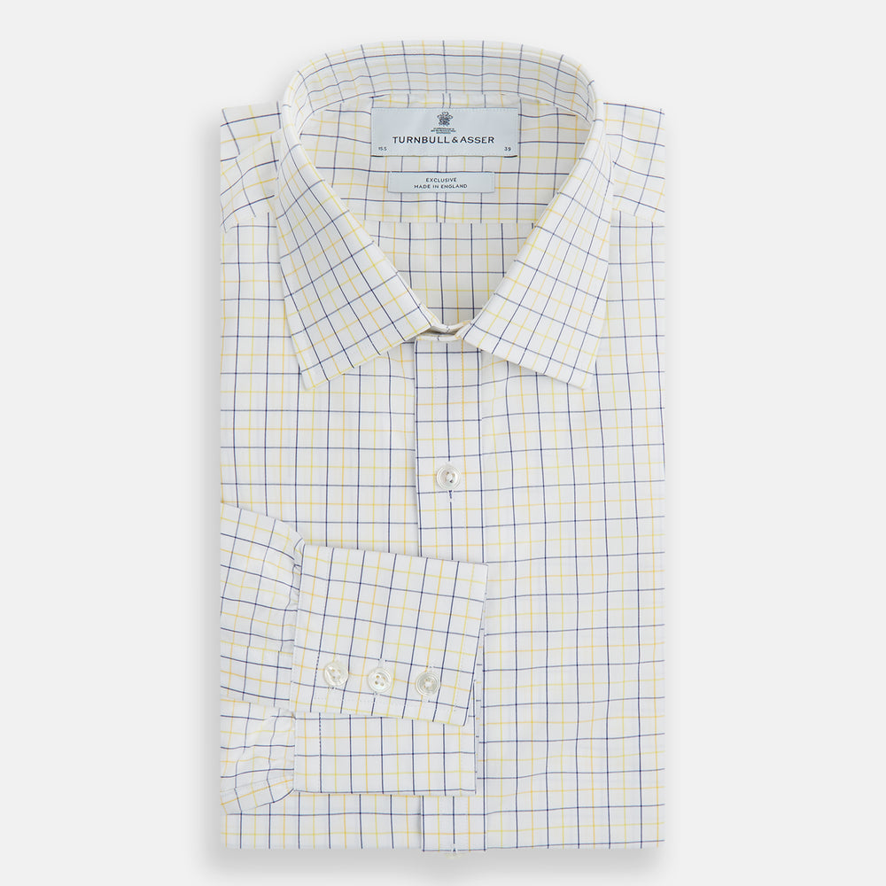 The Turnbull & Asser Yellow Overlay Grid Check Mayfair Shirt is a long-sleeve, button-down shirt made from soft organic cotton, featuring a yellow grid check pattern and shown laid flat on a white background.