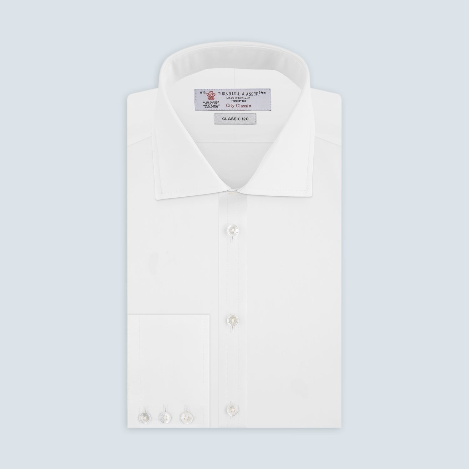 View 1 of product The Turnbull & Asser Two-Fold 120 White Shirt with a Regent collar and 3-button cuffs is neatly folded and displayed against a light blue background.
