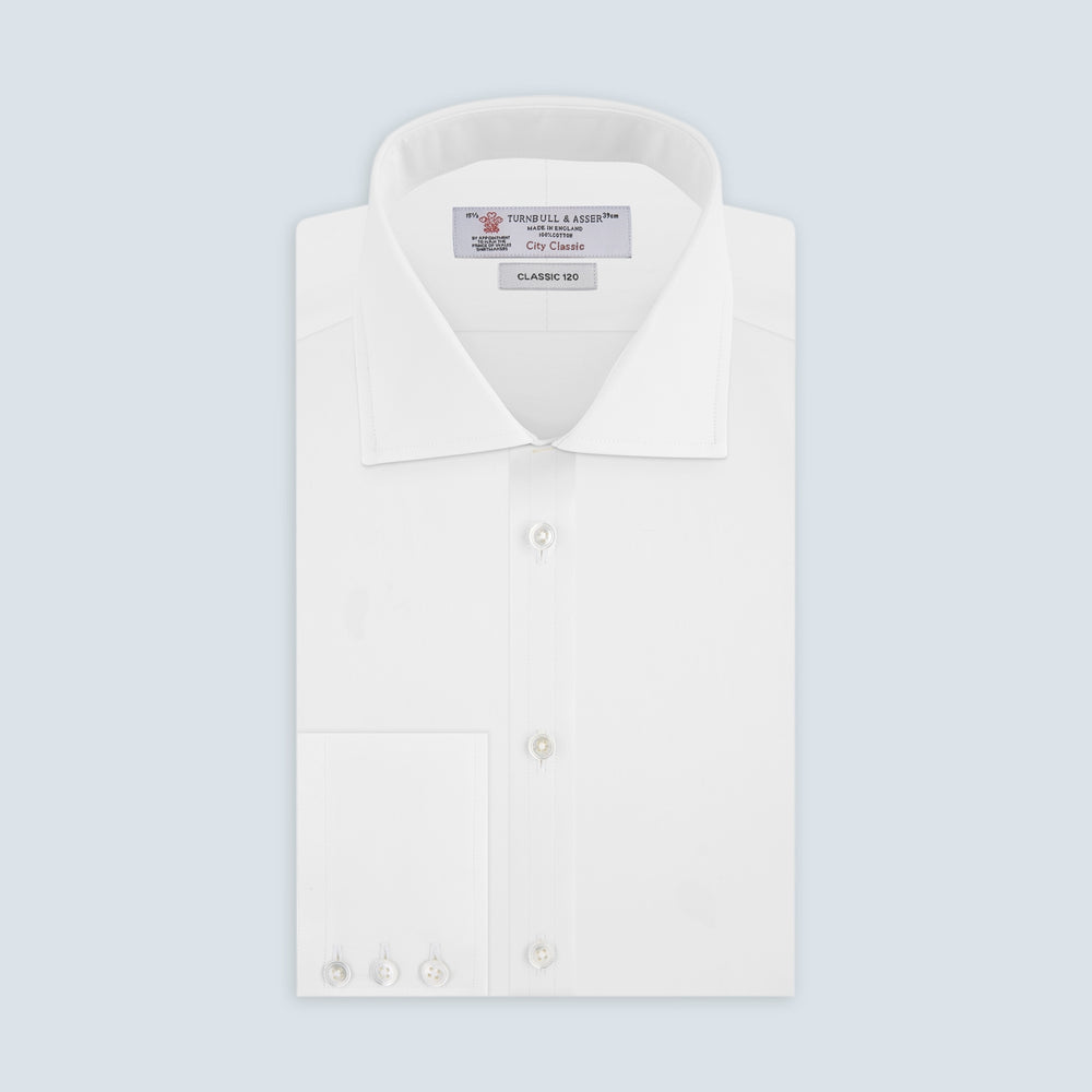 The Turnbull & Asser Two-Fold 120 White Shirt with a Regent collar and 3-button cuffs is neatly folded and displayed against a light blue background.