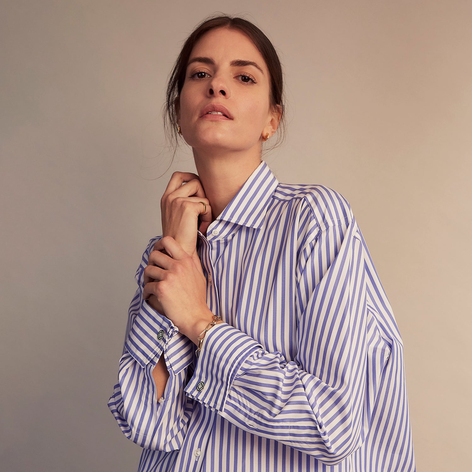 View 6 of product The Turnbull & Asser Pale Blue Candy Stripe Cotton Marlene Shirt is an oversized women's collared shirt with long sleeves, buttoned cuffs, and vertical blue and white stripes, shown laid flat on a white background.