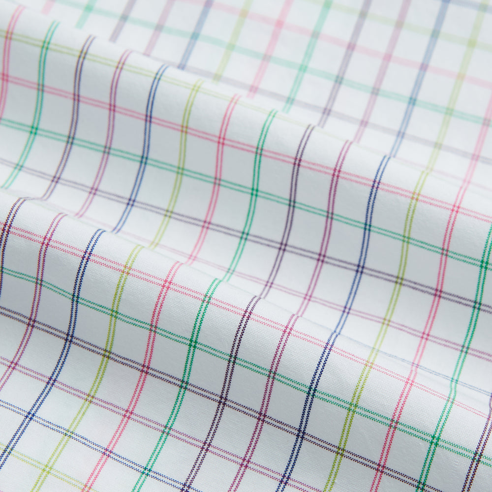 The Turnbull & Asser Multicoloured Double Grid Check Mayfair Shirt, made from organic cotton, features long sleeves, a collar, and a blue, green, and red grid check on white. The shirt is shown neatly laid flat against a white background.
