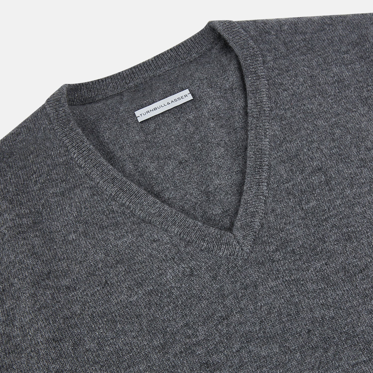 View 2 of product The Turnbull & Asser Storm Grey Cashmere V-neck Jumper features long sleeves, ribbed cuffs and hem—versatile knitwear shown on a white backdrop.