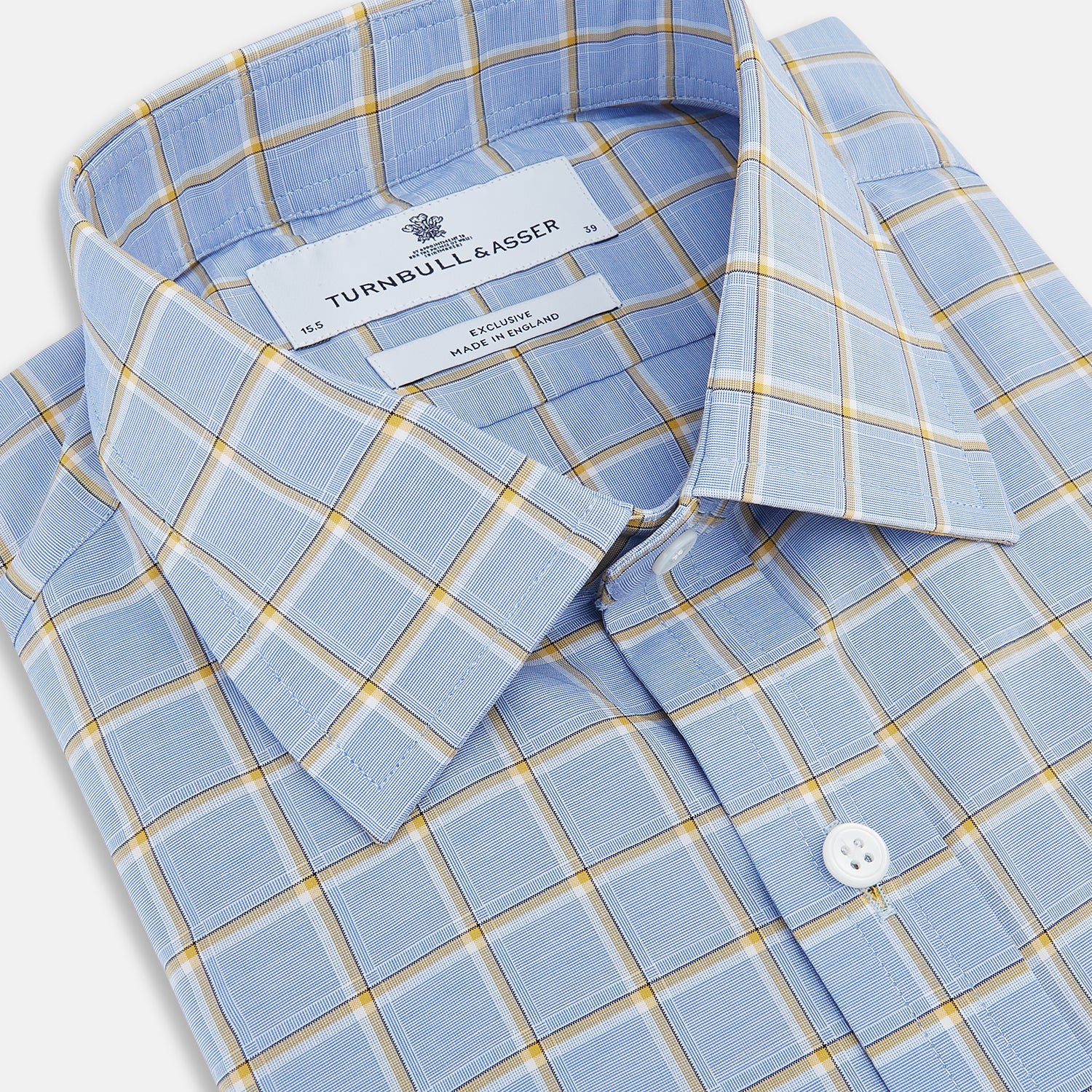 View 2 of product The Turnbull & Asser Blue and Yellow Windowpane Mayfair Shirt is crafted from fine Italian cotton, featuring a light blue base with yellow and white checks, shown on a plain white background.