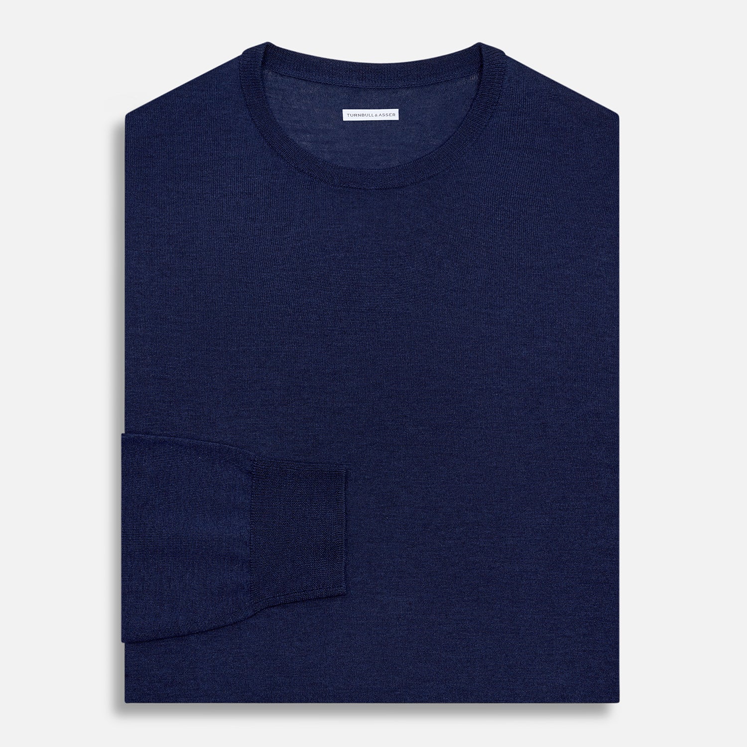 View 4 of product The Turnbull & Asser Navy Merino Round Neck Jumper is shown against a light gray background, featuring a classic long-sleeve design with ribbed cuffs, hem, and neckline for timeless style.