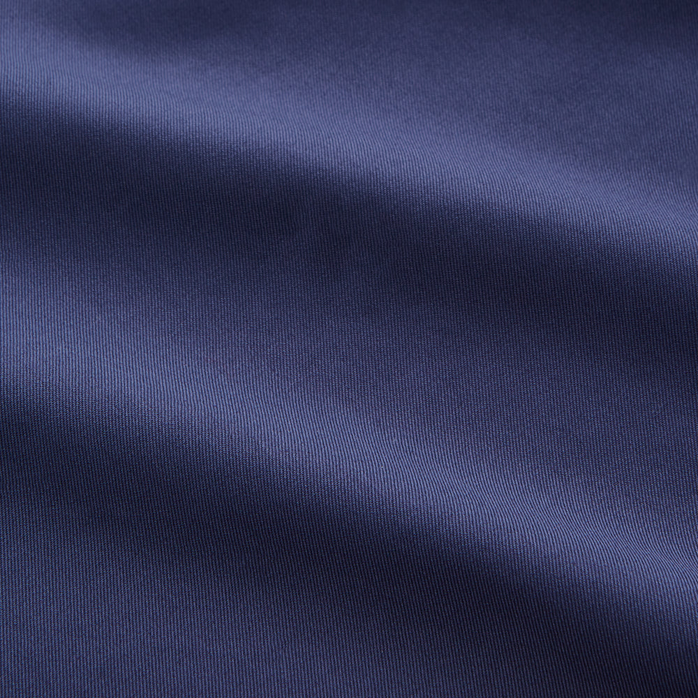 The Blue Piece Dyed Weekend Fit Suffolk Shirt by Turnbull & Asser features a button-down Dorset collar, chest pocket, white buttons, and long sleeves in classic navy, laid flat against a white background.