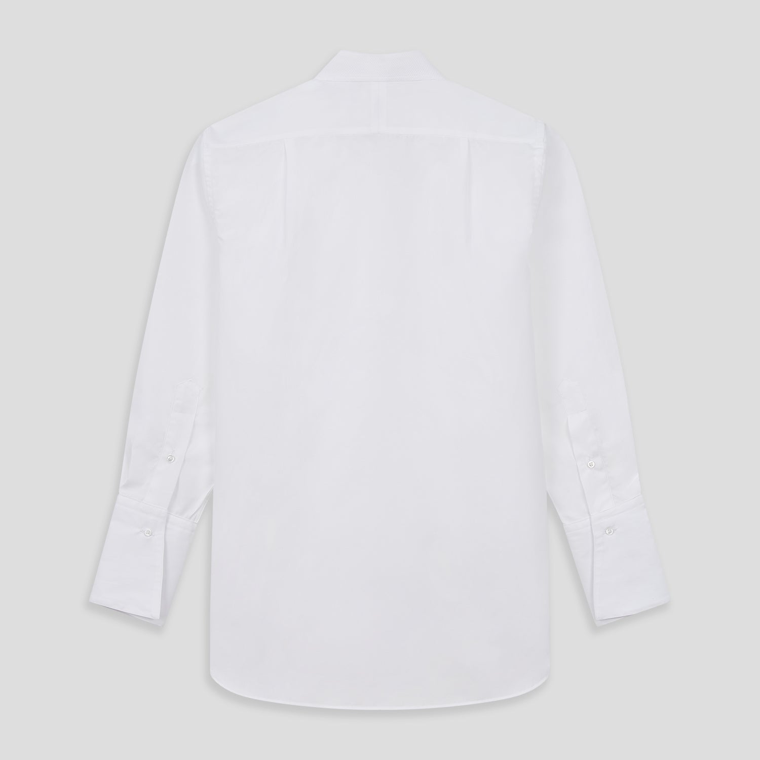 View 3 of product A person with curly hair wears the Turnbull and The Deck White Cotton Minimalist Shirt by Turnbull & Asser, paired with pants. Posed against a plain background, their minimalist silhouette is highlighted in this black and white image.