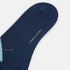 View 3 of product The Azzurro Wool Check Mid-Length Socks by Turnbull & Asser are navy blue with a ribbed cuff, featuring an argyle pattern in light blue, teal, and navy with white accents. Displayed upright against a plain white background.