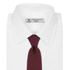 View 2 of product The Turnbull & Asser Plain Woven Grenadine Silk Tie, shown rolled at one end on a white background, features a rich burgundy hue and textured pattern—an essential accessory for sophisticated looks.