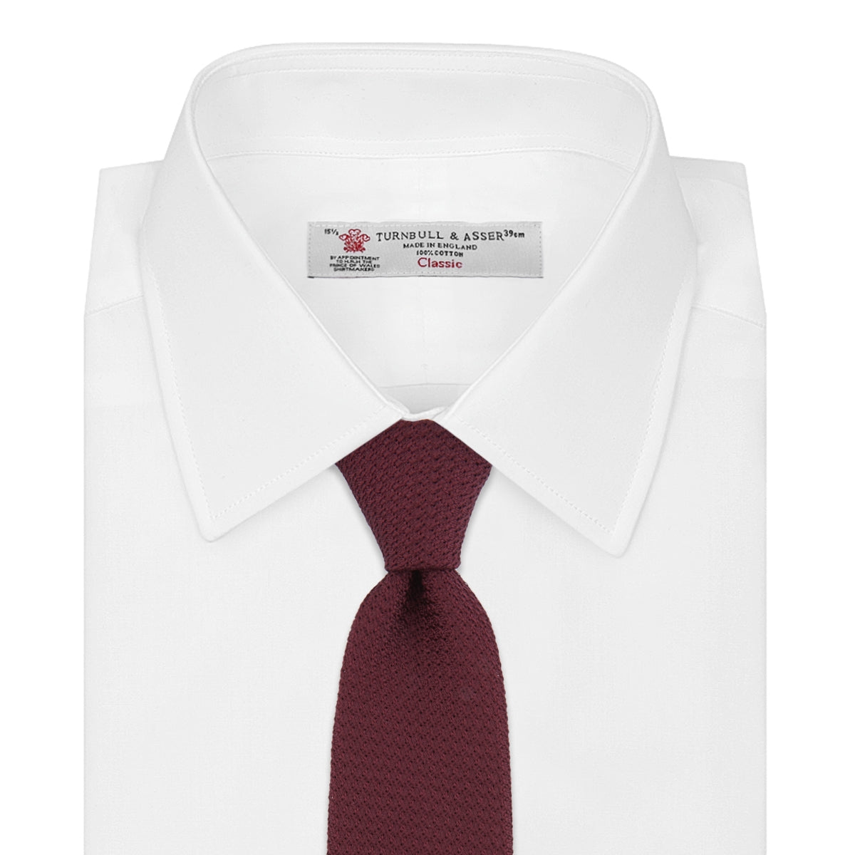View 2 of product The Turnbull & Asser Plain Woven Grenadine Silk Tie, shown rolled at one end on a white background, features a rich burgundy hue and textured pattern—an essential accessory for sophisticated looks.
