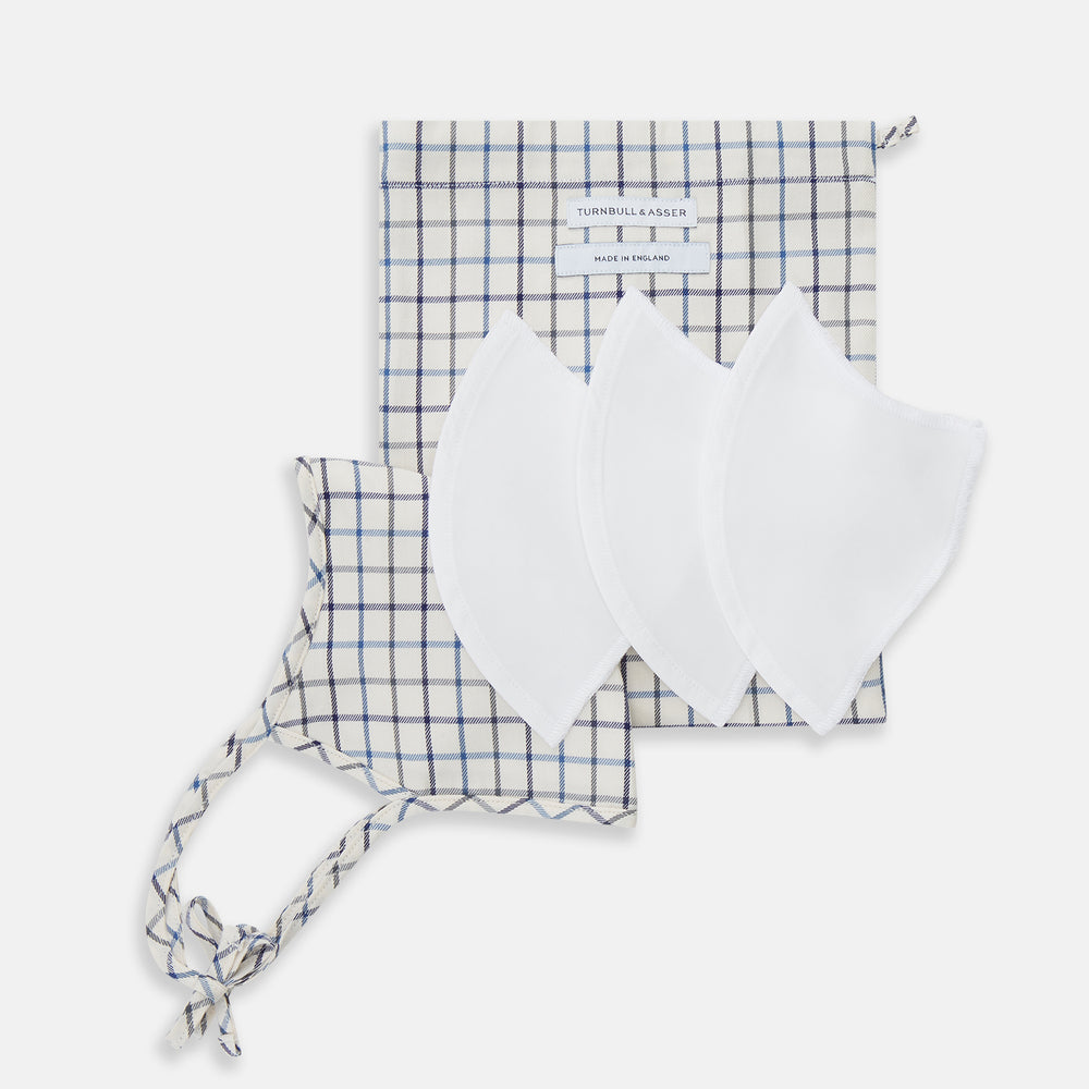 The Turnbull & Asser Check Blue Multi Commuter Mask features a blue plaid design, adjustable fabric ear loops tied in bows, and comes with 3 Viroformula™ filters. Laid flat on a white background.