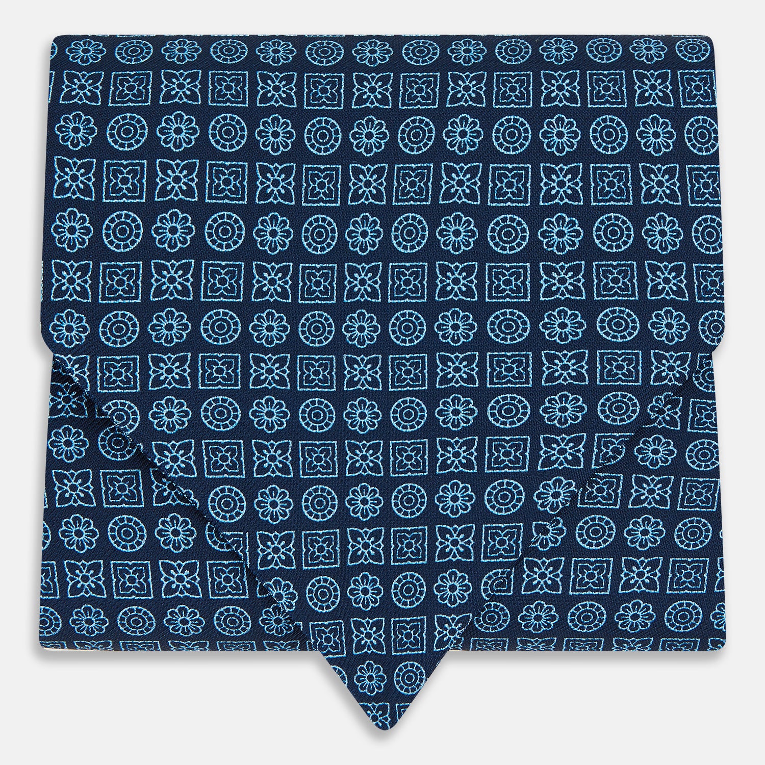 View 1 of product The Turnbull & Asser Dark Navy Floral Tile Pattern Printed Silk Cravat features a British-inspired light blue floral tile design, elegantly displayed on a white background.