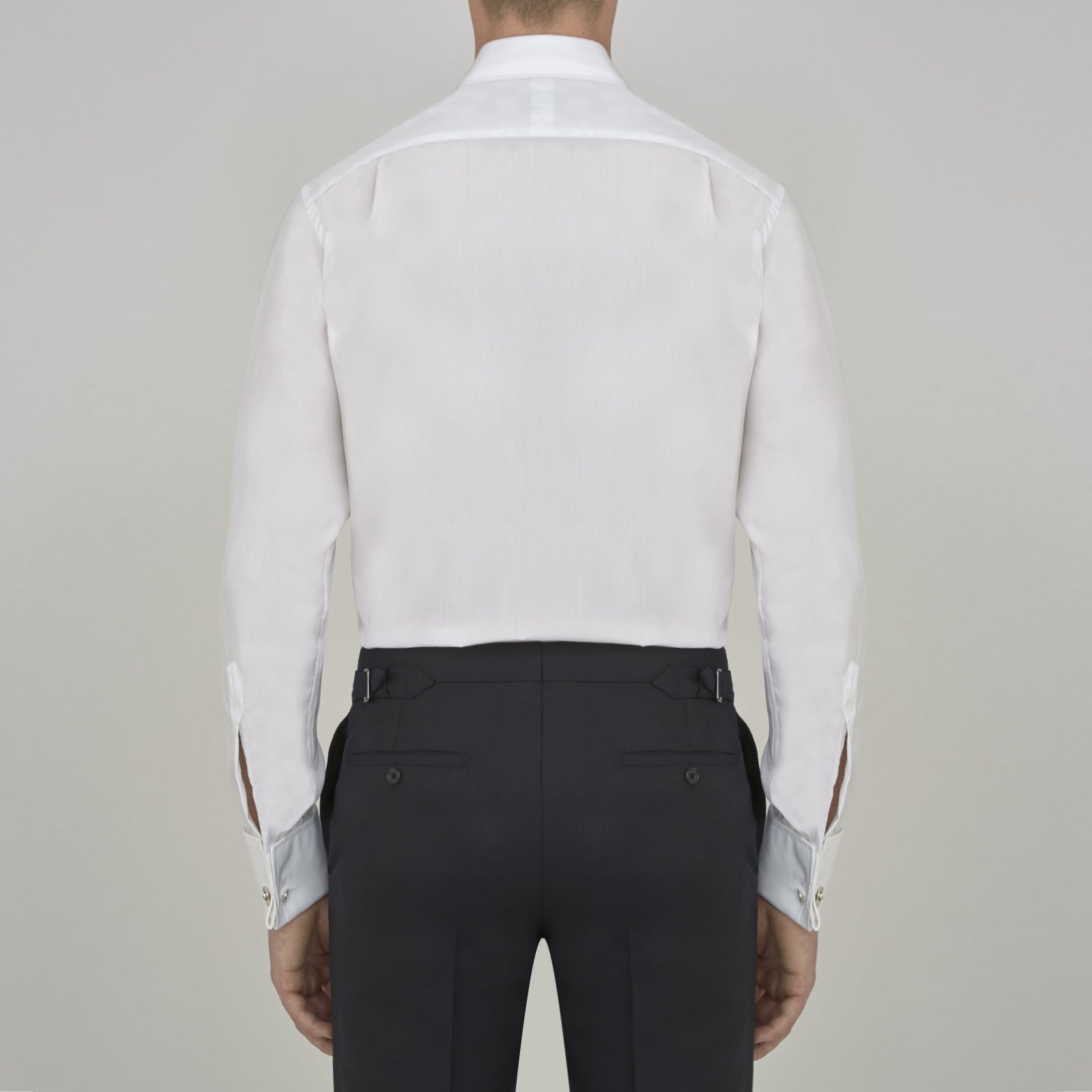 View 3 of product A Turnbull & Asser Two-Fold 200 White Cotton Shirt with T&A collar and double cuffs, neatly folded to show the label inside the collar, is displayed on a light blue background.
