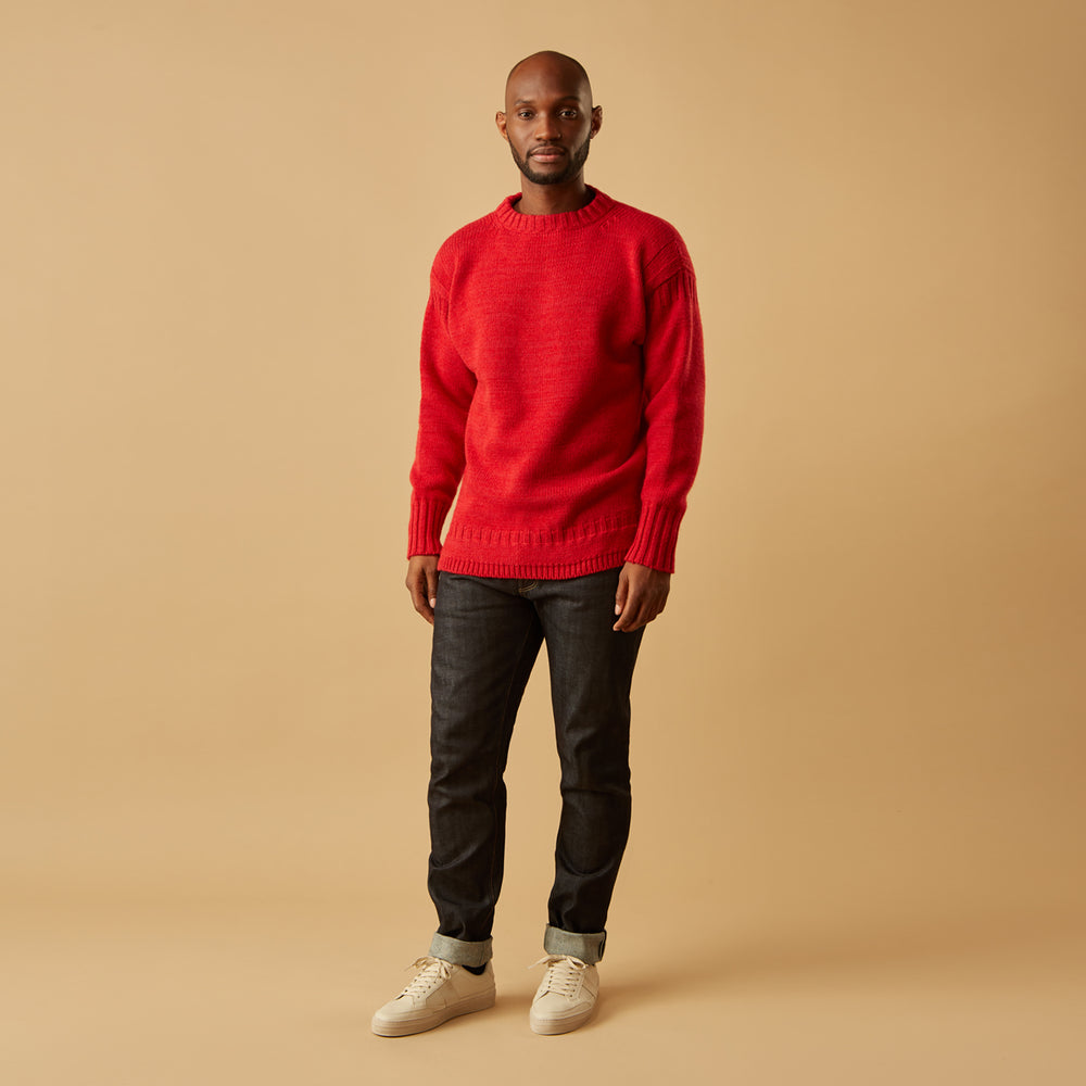 The Red Lewis Guernsey Knitted Jumper by Turnbull & Asser is a bright red wool-cotton, long-sleeve jumper with a round neckline, ribbed cuffs, and ribbed hem, shown against a white background.