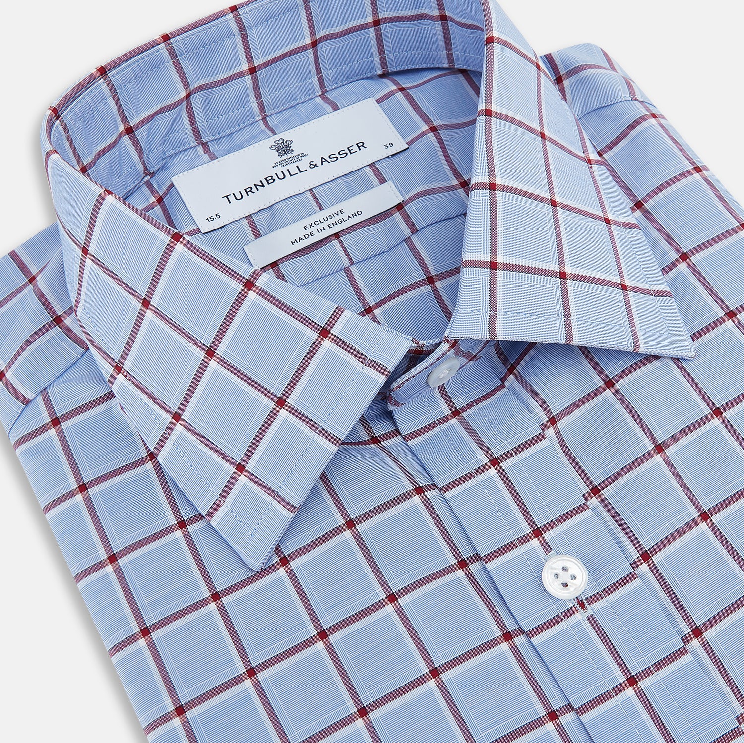 View 2 of product The Turnbull & Asser Blue and Burgundy Windowpane Mayfair Shirt features long sleeves, a light blue base with burgundy windowpane checks, a classic collar, and white buttons.