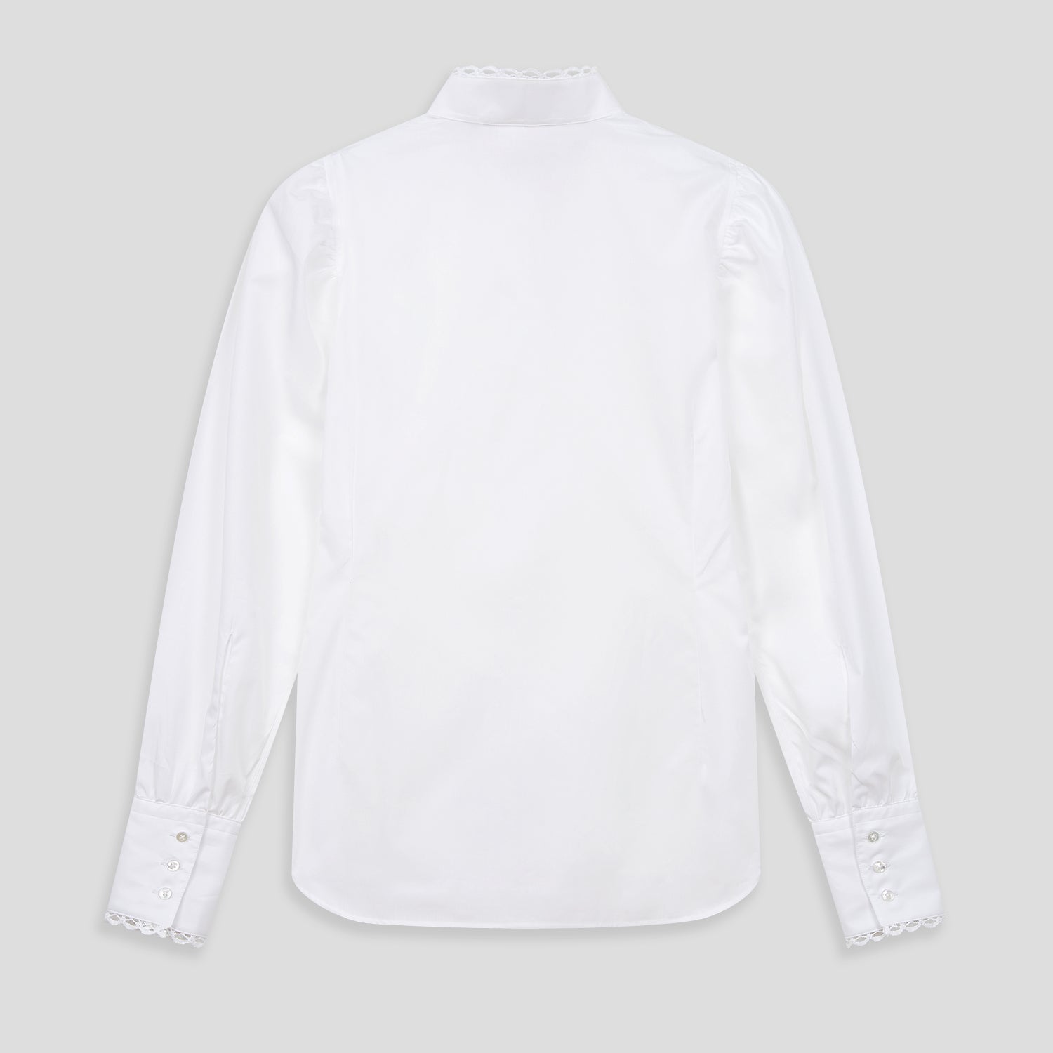 View 3 of product A woman stands in profile, looking down with hands in her pockets, wearing the Turnbull & Asser Turnbull and The Deck White Cotton Expressionist Shirt, paired with high-waisted black-and-white houndstooth pants.