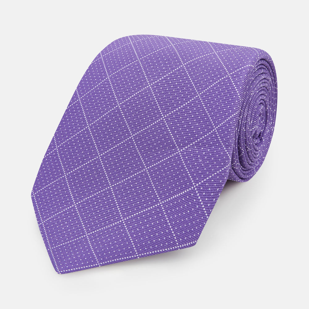 The Turnbull & Asser Purple Dotted Check Pattern Printed Silk Tie is displayed rolled up on a white background, featuring a subtle check design for an elegant look.