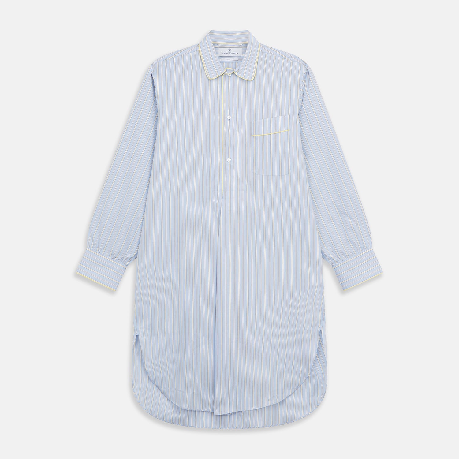 View 1 of product The Turnbull & Asser Blue and Yellow Stripe Poplin Cotton Nightshirt features light blue and yellow vertical stripes, long sleeves, a classic collar, single chest pocket, rounded hem, and is displayed flat on a white background.