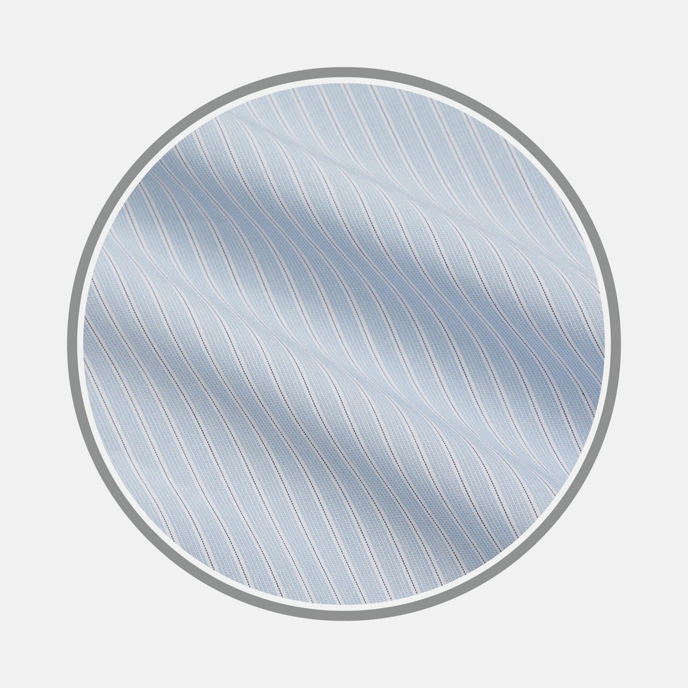 Close-up of Turnbull & Asser's Pale Blue Stripe West Indian Sea Island Cotton Fabric, featuring thin white diagonal stripes and a smooth texture, displayed in a circular frame on a plain light background.