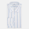 View 5 of product The Colony Blue Track Stripe Mayfair Shirt by Turnbull & Asser is a long-sleeve, button-up Italian cotton shirt with a white base and blue stripes, pointed collar, and buttoned cuffs, shown laid flat on a white background.