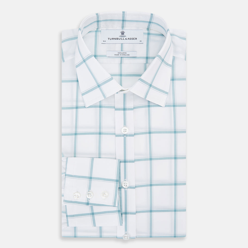 The Turnbull & Asser Sage Grid Check Mayfair Shirt is a white, long-sleeve shirt made from Italian cotton with a light blue and sage grid pattern, shown neatly laid flat on a plain, light background.