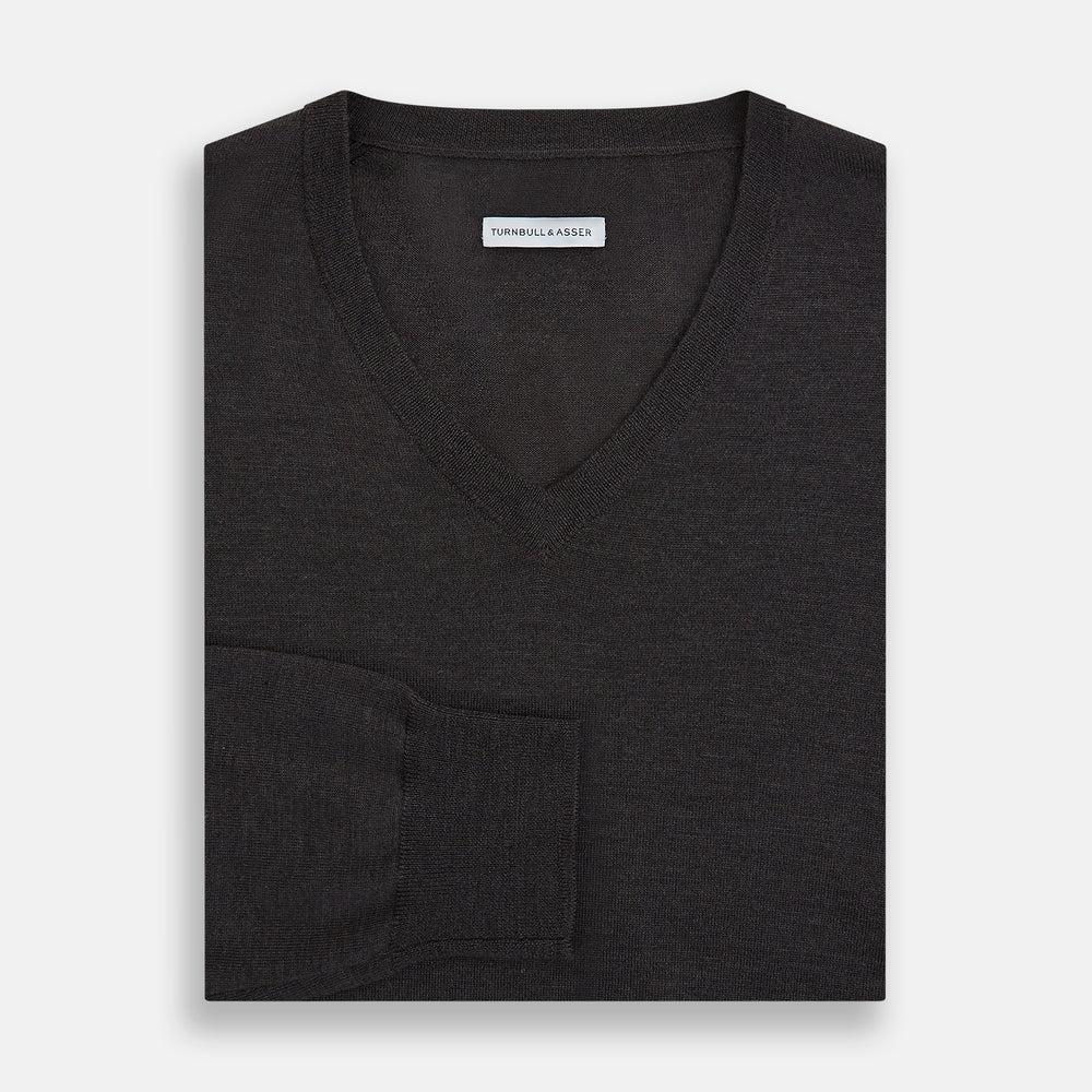 The Turnbull & Asser Charcoal Grey Merino V Neck Jumper is a classic long-sleeve knit with ribbed cuffs and hem, featured in our knitwear collection and shown against a white background.