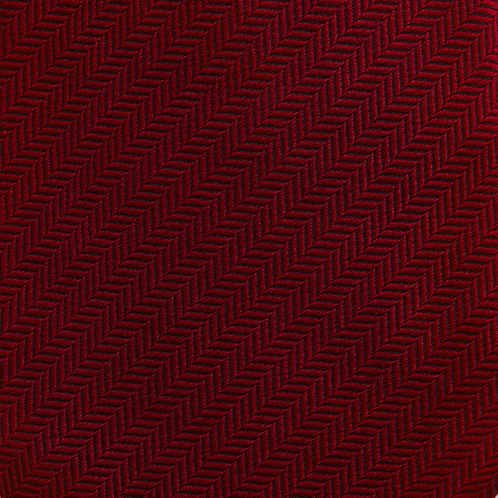 The Turnbull & Asser Plain Herringbone Burgundy Tie features a subtle pattern and rich color, making it an essential accessory for smart attire. Neatly rolled, it’s elegantly displayed on a plain white background.