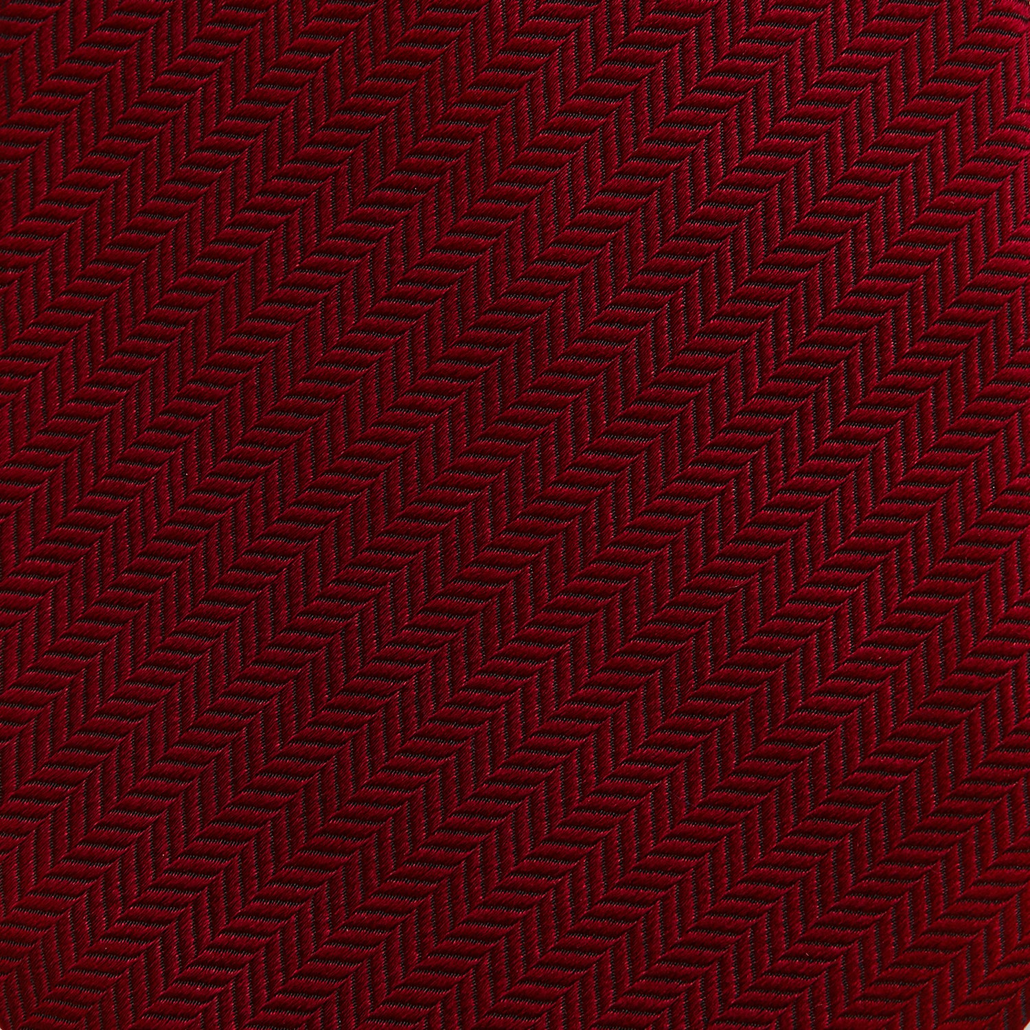 View 3 of product The Turnbull & Asser Plain Herringbone Burgundy Tie features a subtle pattern and rich color, making it an essential accessory for smart attire. Neatly rolled, it’s elegantly displayed on a plain white background.