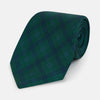 View 1 of product The Turnbull & Asser Forest Melange Tartan Plaid Silk Tie features a classic green and blue plaid design, rolled up and displayed on a plain light background—reflecting timeless Scottish heritage.