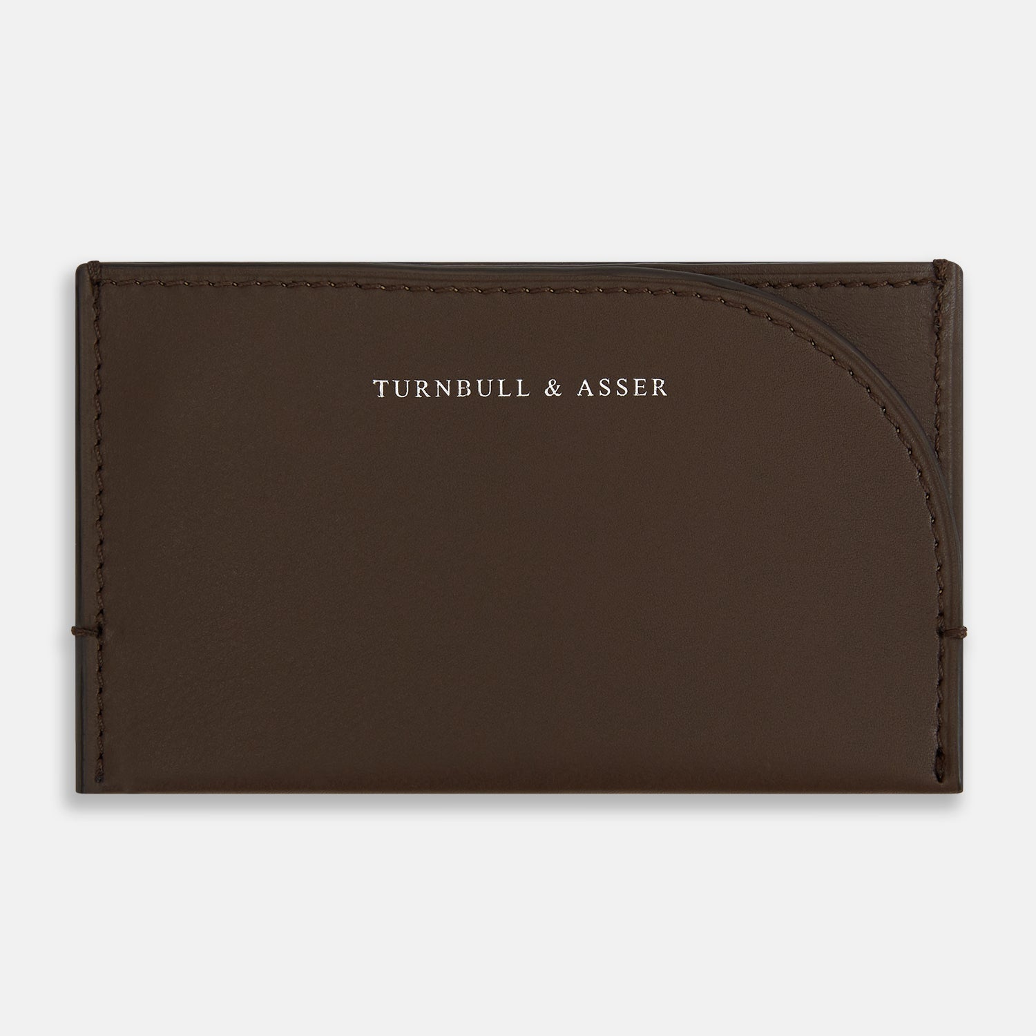 View 1 of product Crafted from dark chocolate leather, the Turnbull & Asser Slim Rounded Card Case features a curved right edge, clean stitching, and the brand’s white embossed logo.
