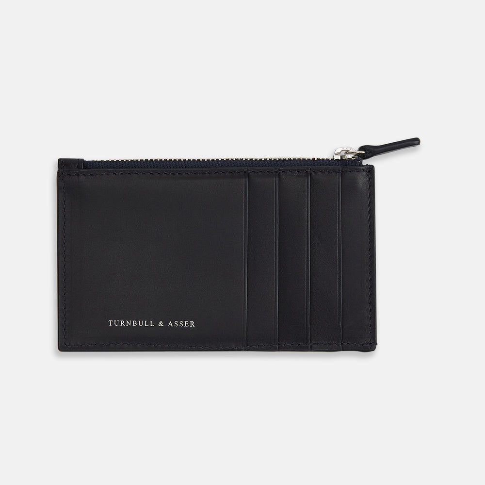 A navy leather card holder by Turnbull & Asser, featuring four card slots, a zip coin pocket, and the brand name embossed in white on the lower left corner.