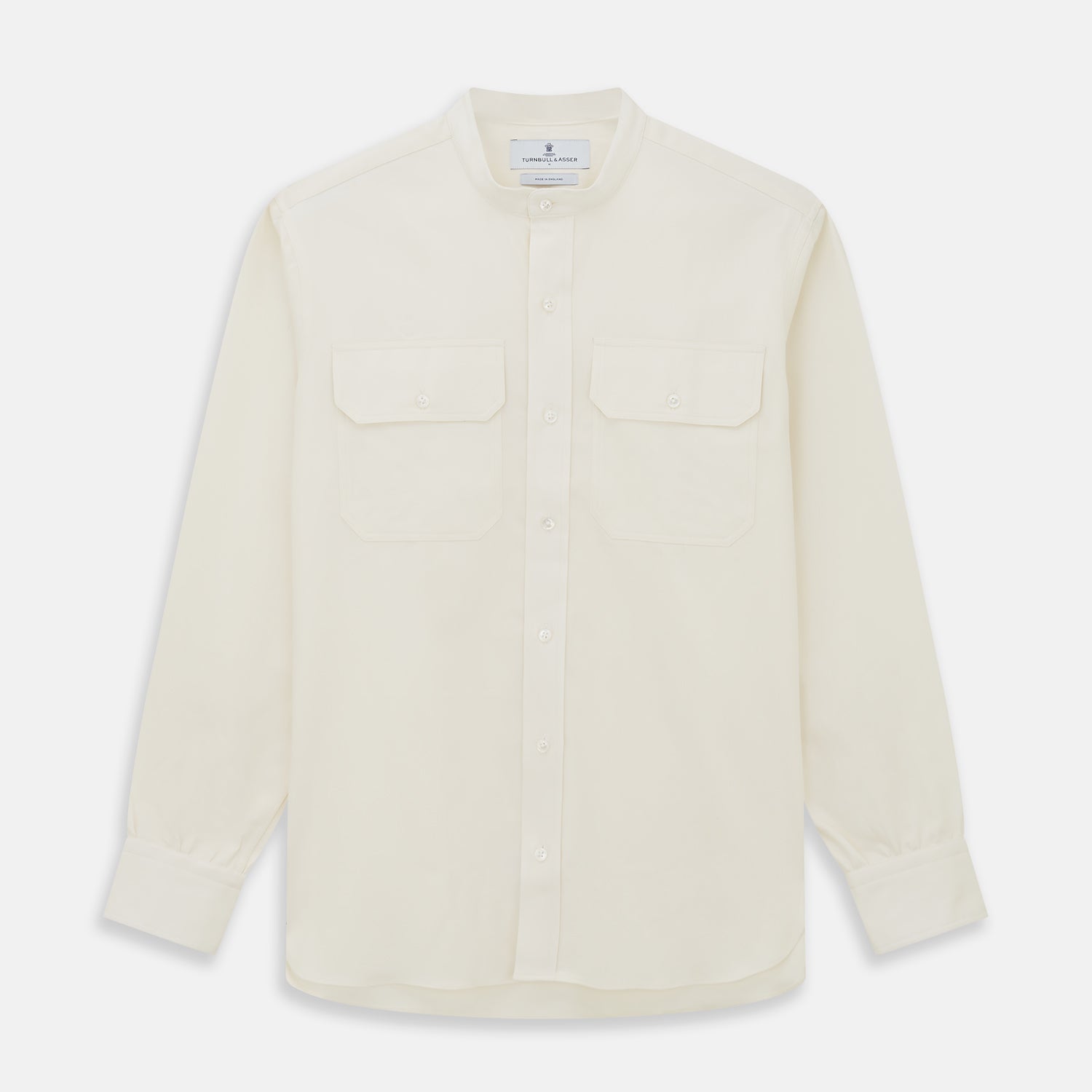 View 1 of product The Turnbull & Asser Cream Cotton Weekend Fit Unwin Shirt features long sleeves, a stand collar, and two chest pockets, shown laid flat on a white background.