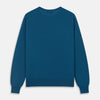 View 4 of product A man with light skin and short brown hair stands against a plain background, wearing the Turnbull & Asser Ocean Blue Merino Kingston Crew Neck Jumper and cream-colored pants, looking directly at the camera with a neutral expression.
