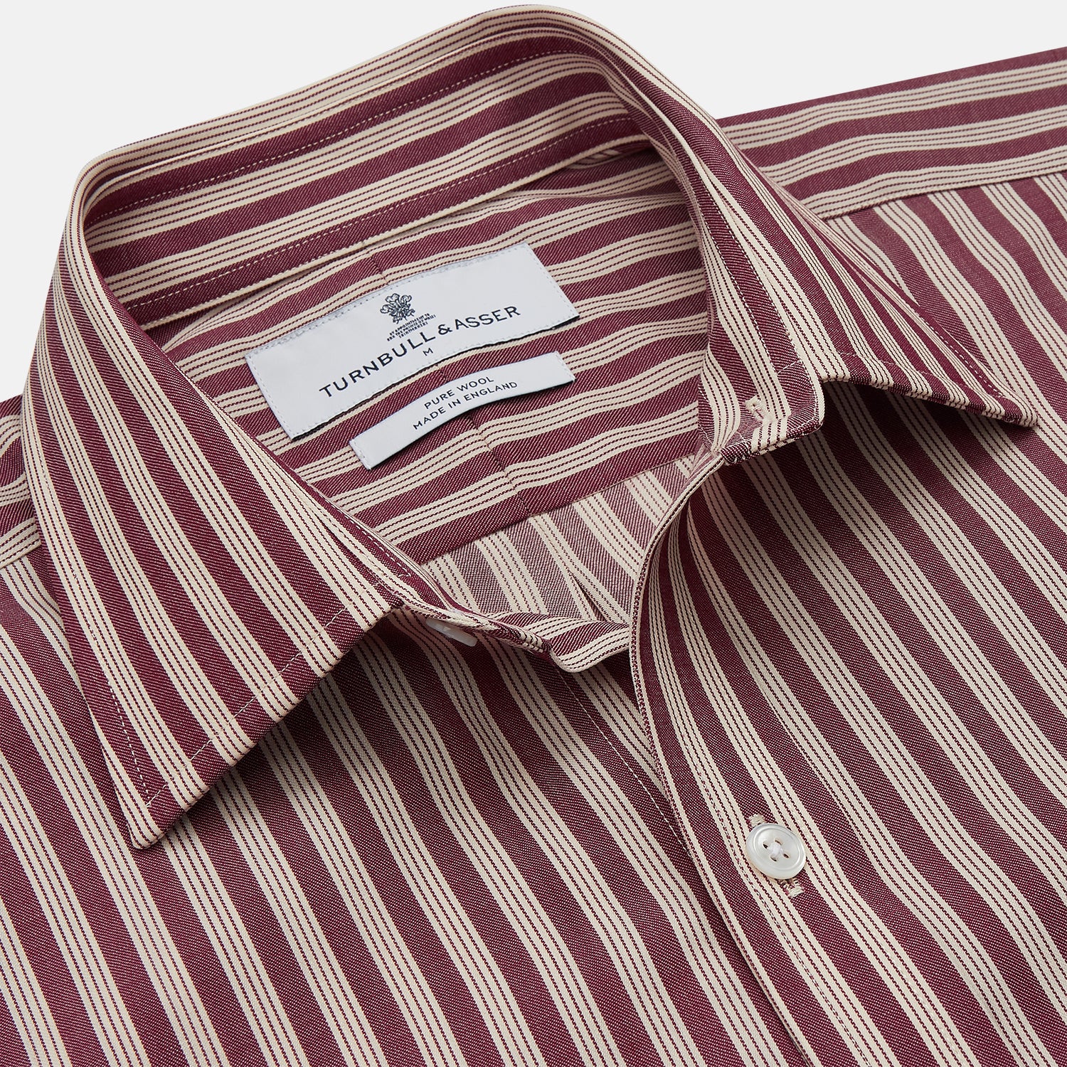 View 2 of product The Turnbull & Asser Burgundy Multi Stripe Weekend Fit Wool Shirt features a Derby collar, 1 button cuffs, and vertical red and white stripes, ideal for casual wear, shown against a white background.