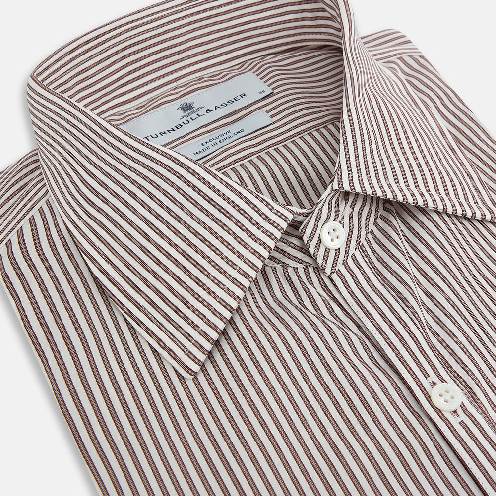 The Burgundy Halo Stripe Westminster Shirt by Turnbull & Asser features long sleeves, a button-up front, a Westminster collar, and thin vertical brown and white stripes, shown on a plain white background.