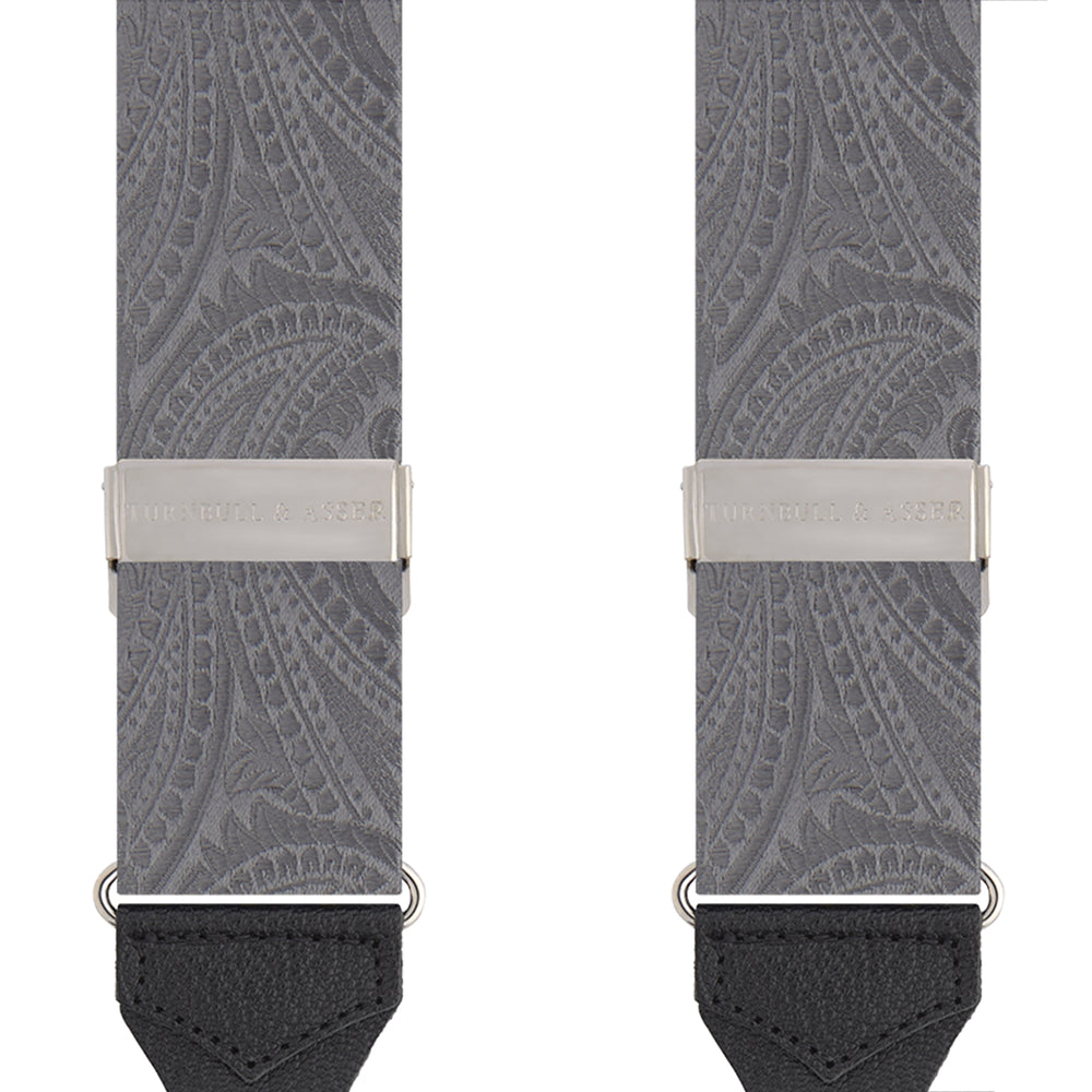 The Turnbull & Asser Silver Paisley Adjustable Silk Braces feature gray paisley silk with silver fittings and black leather ends, offering refined style. The symmetrical braces are displayed flat on a white background.