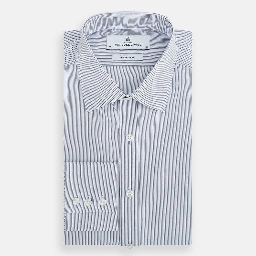 The Navy and White Ticking Stripe Mayfair Shirt by Turnbull & Asser features long sleeves, buttoned cuffs, a pointed T&A collar, and button-up front, shown on a plain white background.