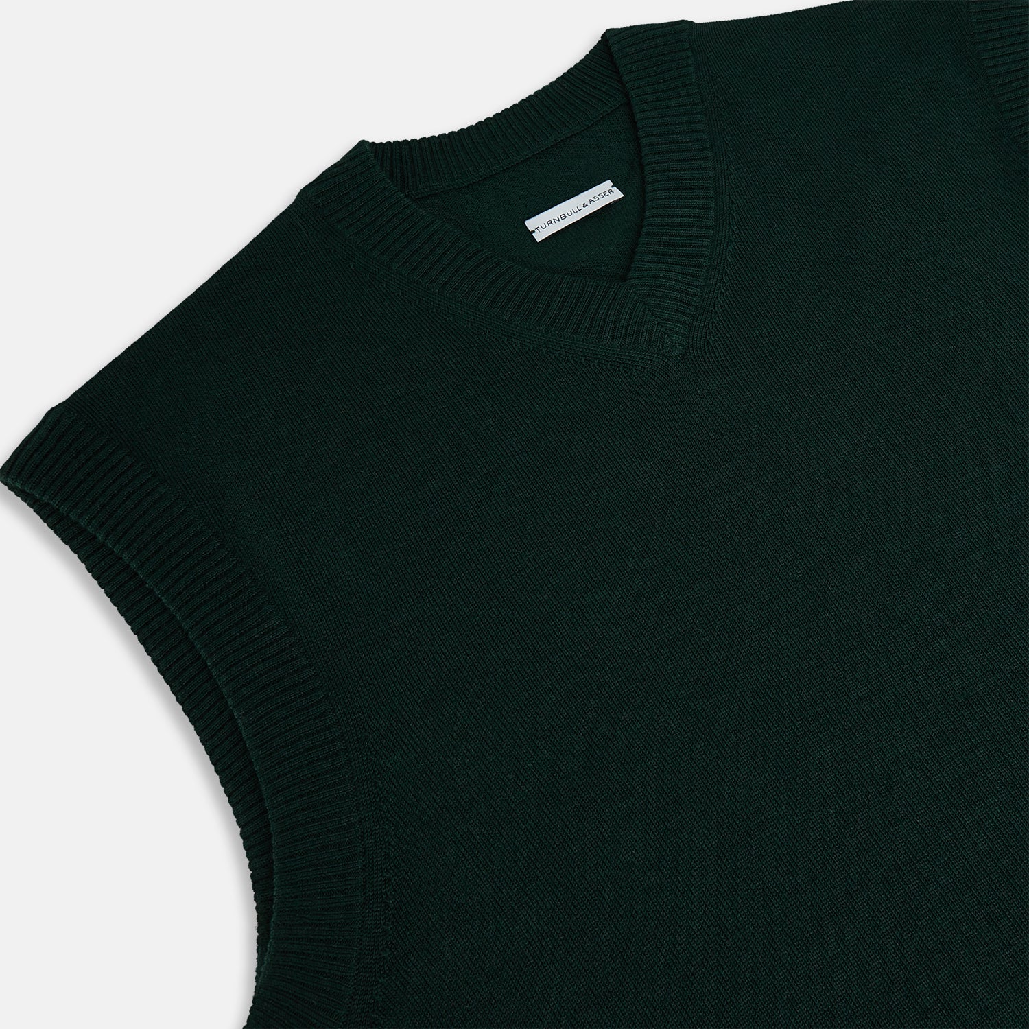 View 2 of product The Turnbull & Asser Forest Green Fine Merino V-Neck Vest is a sleeveless knitwear piece with ribbed edges, shown on a plain white background—ideal for elevating men’s sophisticated wardrobes.