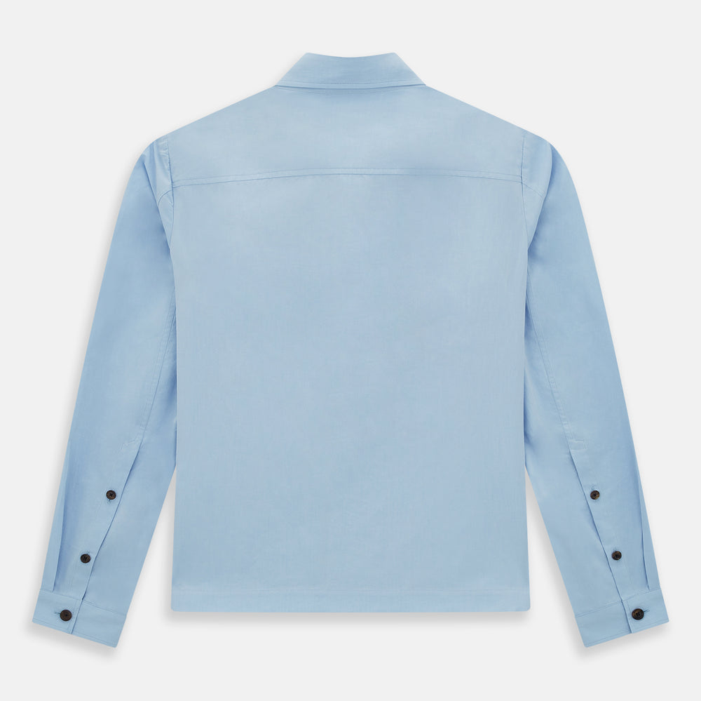 The Blue Hyde Overshirt by Turnbull & Asser features a light blue hue, long sleeves, a button-up front, and a single chest pocket. Crafted from sanforised cotton and shown laid flat on a white background.
