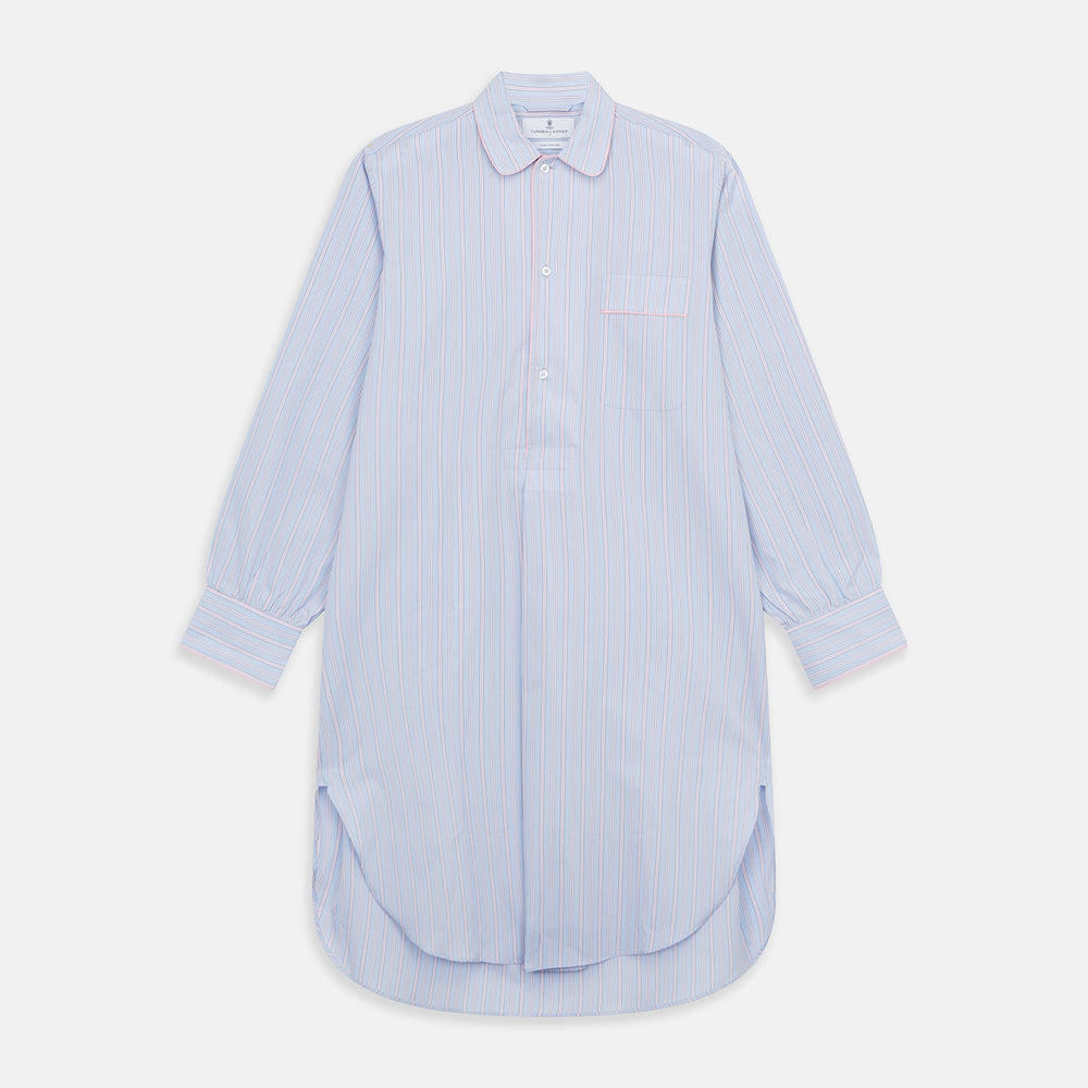 The Blue and Pink Stripe Poplin Cotton Nightshirt by Turnbull & Asser features long sleeves, a collar, front buttons, chest pocket, rounded hem, and light blue fabric with white, pink, and yellow vertical stripes.
