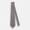 View 2 of product The Turnbull & Asser Ash Medallion Silk Tie features rolled-up ash silk with gray and light purple medallion and grid-like motifs on a white background.