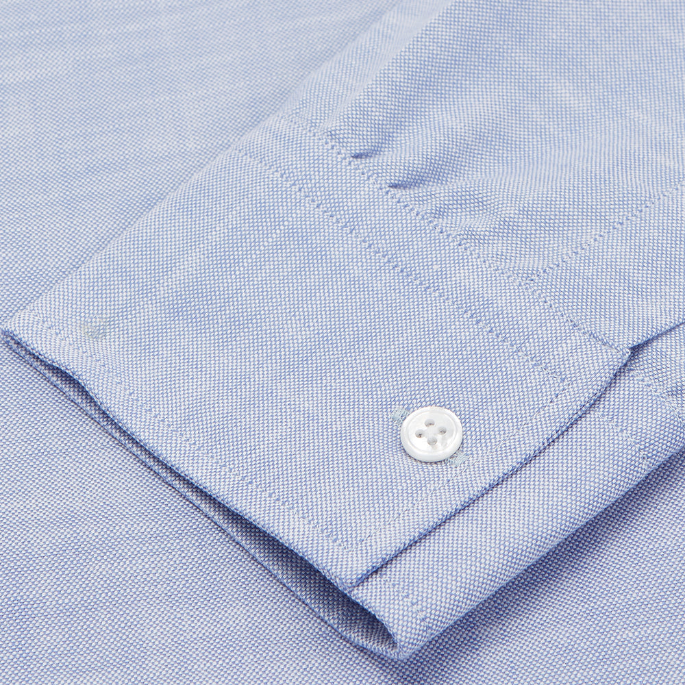 The Turnbull & Asser Mid-Blue Chambray Weekend Fit Shirt features a Dorset collar, white buttons, and 1-button cuffs. It is laid flat on a white background.