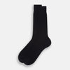 View 2 of product A single Midnight Mid-length Sock by Turnbull & Asser, made from mercerised Egyptian cotton, stands upright on a white background. This luxury black sock features a ribbed texture with smooth toe and heel areas.
