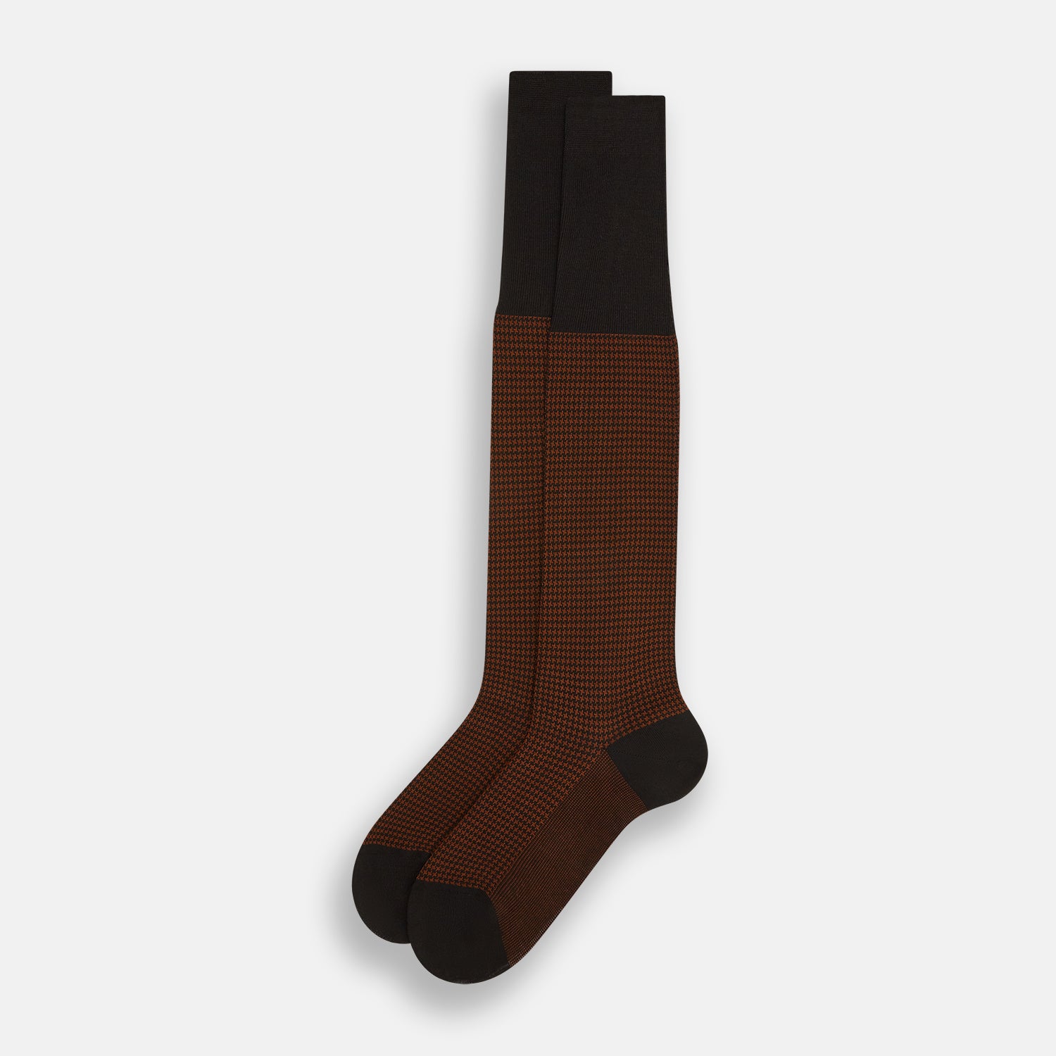 View 2 of product The Turnbull & Asser Rust Houndstooth Long Sock is a single knee-high sock crafted from soft Egyptian cotton, featuring a dark brown and black check pattern, solid dark brown top band, and reinforced heel and toe. Displayed on a white background.