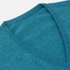 View 2 of product The Teal Paden V-Neck Jumper by Turnbull & Asser is a pure cashmere sweater in teal blue, featuring long sleeves with ribbed cuffs and hem, shown flat on a light gray background.