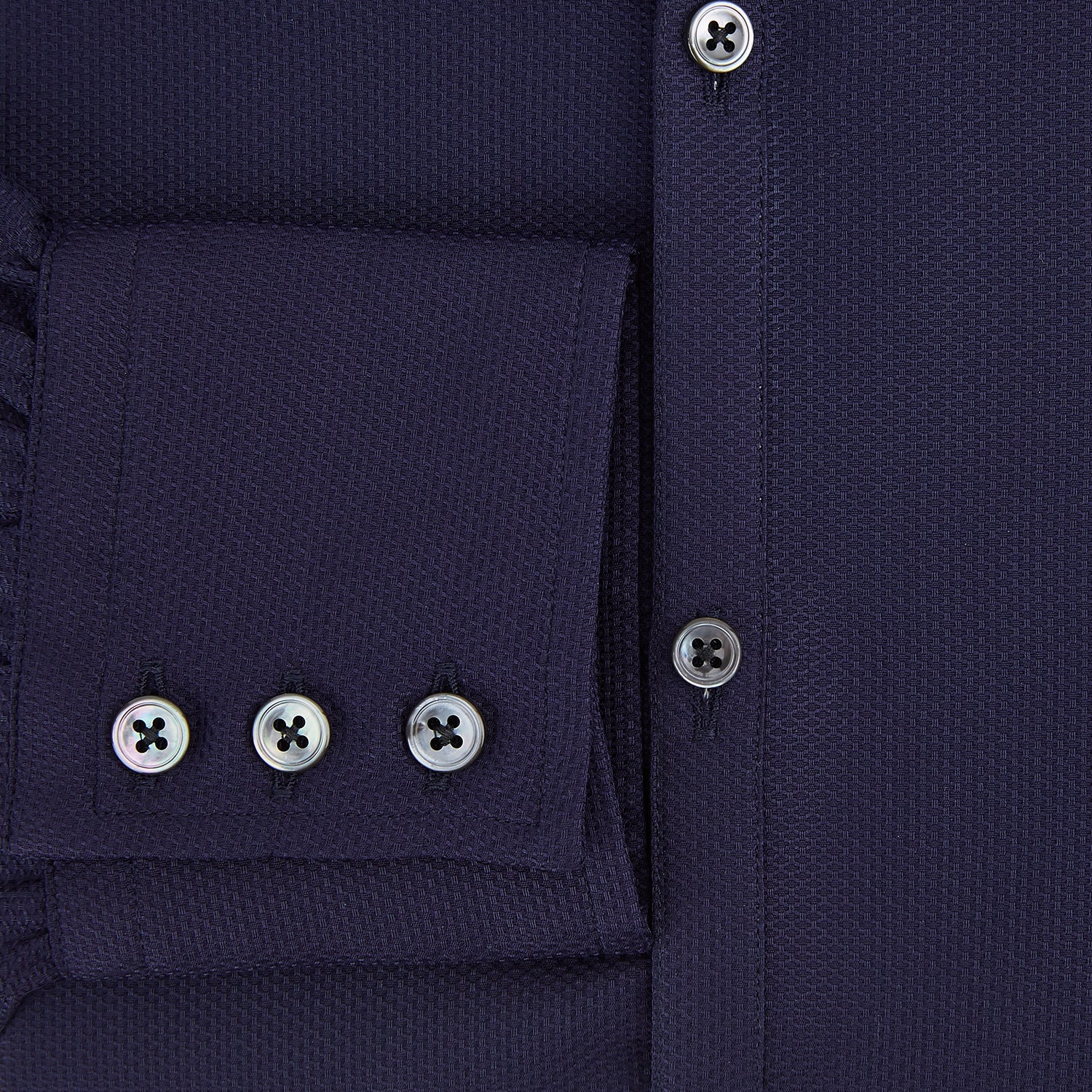 View 4 of product The Navy Textured Windsor Shirt by Turnbull & Asser features long sleeves, a Windsor collar, buttoned cuffs, and white buttons—a fine example of British craftsmanship—set against a plain white background.