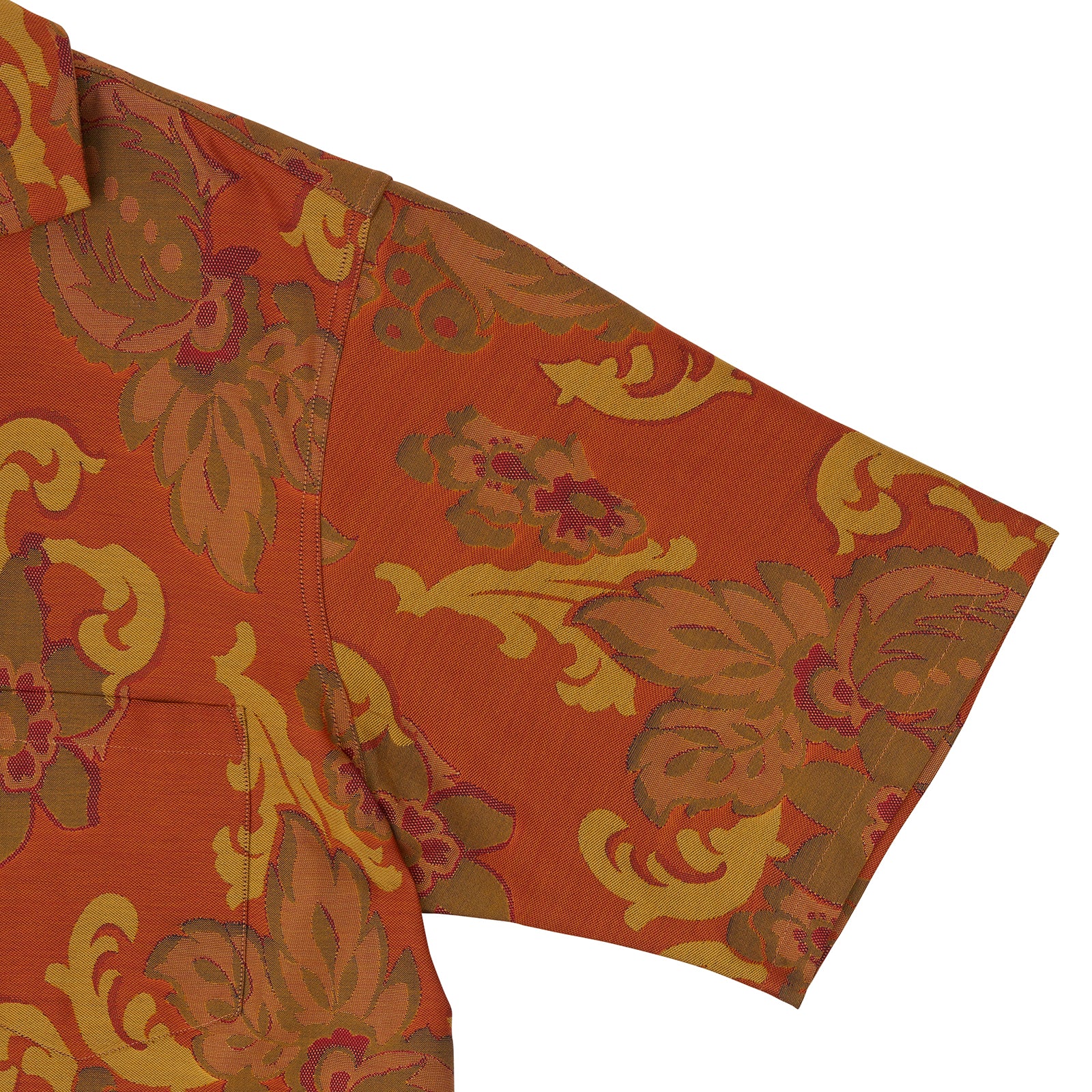 View 4 of product The Orange & Ochre Tapestry Weave Cotton Holiday Fit Shirt by Turnbull & Asser is a short-sleeve, revere collar shirt featuring a yellow and brown floral and leaf pattern on an orange base, finished with white buttons.