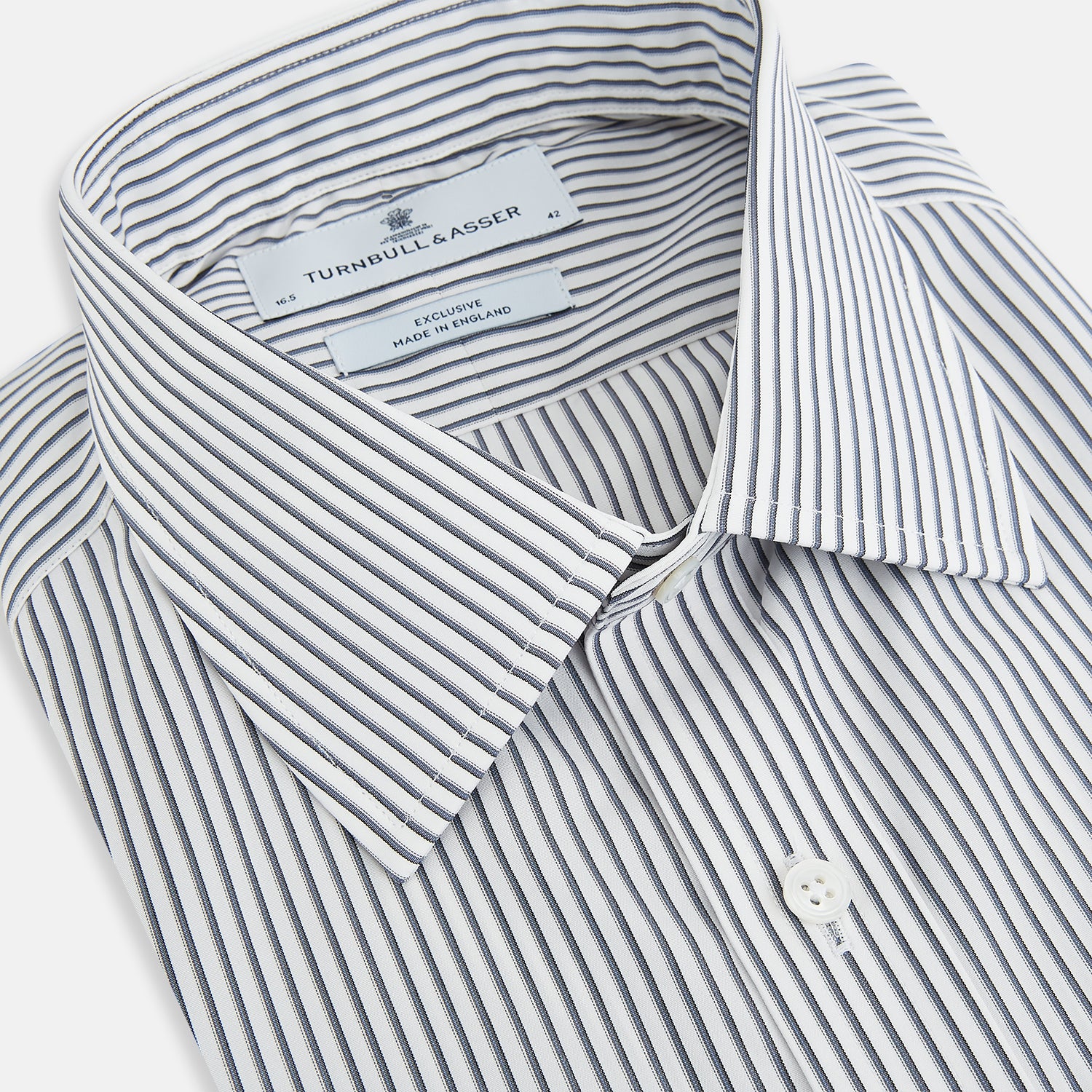 View 2 of product The Turnbull & Asser Grey Multi Stripe Mayfair Shirt features long sleeves, a classic collar, and thin vertical stripes in black and white, shown laid flat on a white background.