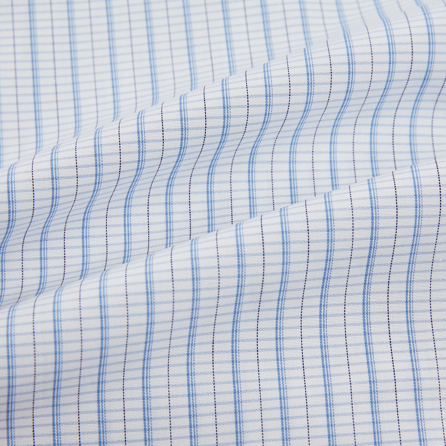 View 6 of product The Turnbull & Asser Blue Graph Check Mayfair Shirt features a classic T&A collar, Mayfair fit, buttoned cuffs, and long sleeves with light blue graph checks on a white background.