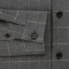 View 4 of product The Turnbull & Asser Charcoal Melange Check Hampstead overshirt, a long-sleeve button-up with a collar and two zippered side pockets, is laid flat on a light gray background.